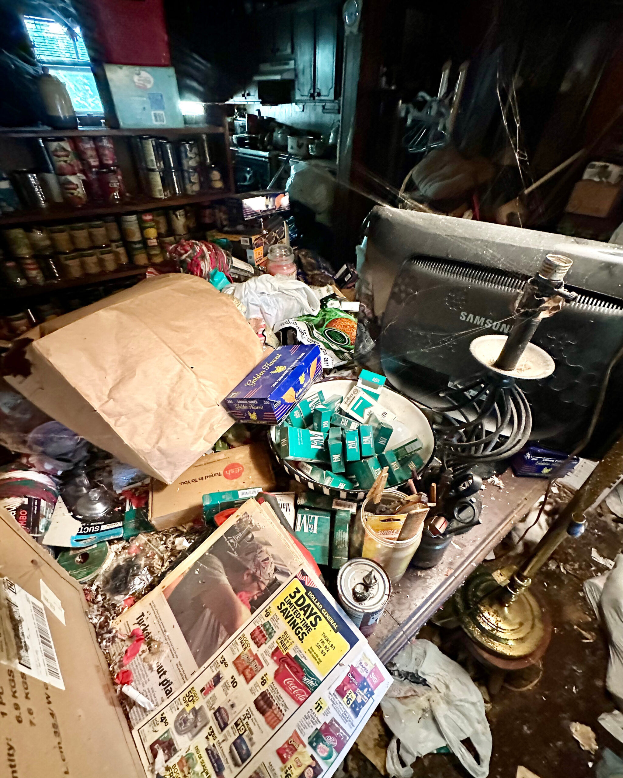 An extremely cluttered room is full of trash and detritus.